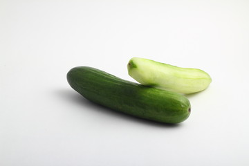 whole peeled and unpeeled fresh cucumber on white background