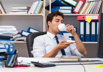 Businessman working in the office with piles of books and papers