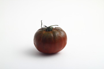 Black organic tomatoes with cuttings. Round black tomatoes. On a white background, isolated. Close-up. Still life.