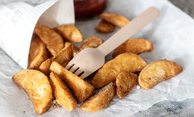 Potato wedges with wooden fork tomato sauce