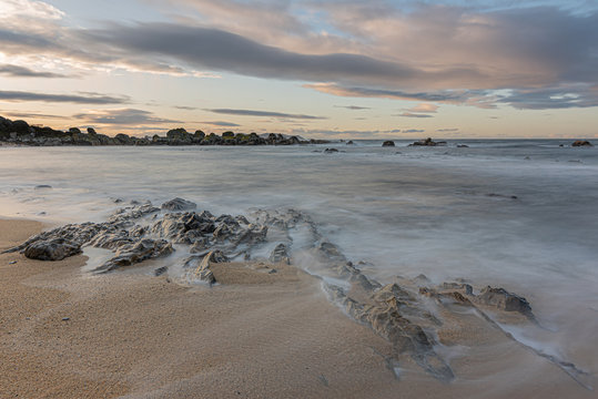 Beautiful exposure long in a rocky beach at sunset, sunrise, with a cloudy sky in San Vicente do Mar, A Lanzada, O Grove, Sanxenxo, Pontevedra, Galicia, Spain.