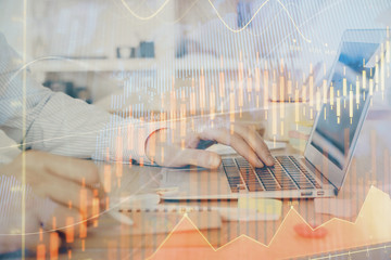 Multi exposure of stock market graph with man working on laptop on background. Concept of financial analysis.
