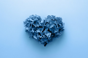 Classic Valentine's heart shape made of flowers on blue color. Flat lay. Year 2020, Love concept.
