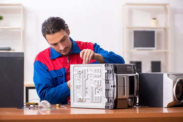 Obraz premium Young engineer repairing musical hi-fi system