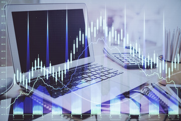 Stock market graph on background with desk and personal computer. Double exposure. Concept of financial analysis.