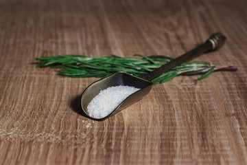 A beautiful vintage scoop with fragrant spices, on green sprigs of rosemary, on a white oak kitchen board. Recipe book with meat dishes and salads. Vintage still life in warm colors.