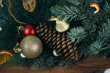 a large fir cone lies in coniferous branches, dressed up with Christmas toys. a Golden bell and a ball