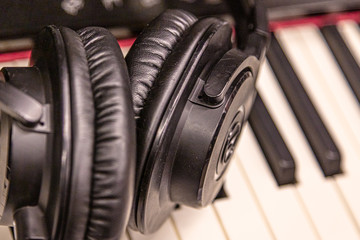Fototapeta na wymiar Piano keyboard with headphones for music Headphones on piano keyboard, close up