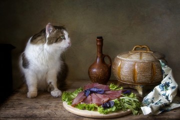 Still life with smoked meat and hungry cute cat