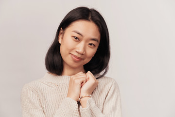 Flattered cute tender feminine young woman press palm chest grateful tilting head smiling. Pleased appreciating nice compliment. Businesslike young woman dressed in knitted warm sweater stands