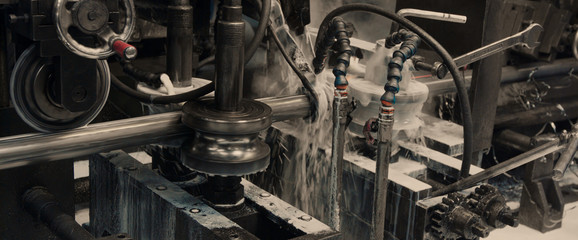 Steel cog gear set of metal sheet bending machine in metalwork factory.