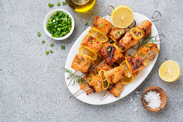 Baked salmon skewers with lemon and green onion.