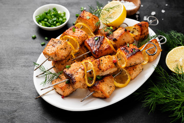 Baked salmon skewers with lemon and green onion. - obrazy, fototapety, plakaty
