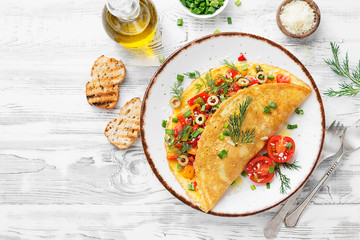 Healthy breakfast food, Stuffed egg omelette with tomato , grilled pepper, green olives and parmesan cheese.