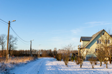 A snowy road by village houses in the Estonian winter
