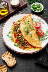 Healthy breakfast food, Stuffed egg omelette with tomato , grilled pepper, green olives and parmesan cheese.