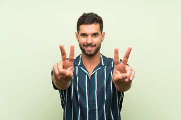 Handsome man over isolated background smiling and showing victory sign