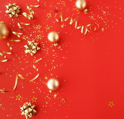 christmas or new year decorations background in gold colors on red  background with empty copy space for text. holiday and celebration concept for postcard or invitation. top view 