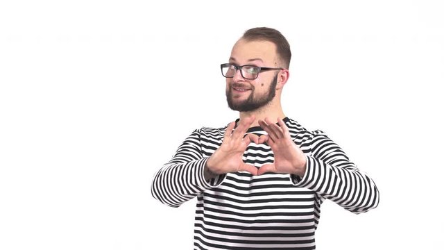 Close-up of a young man making gest hands in heart shape, heart health insurance, social responsibility, donation charity concept, world heart day, International Day of Sign Languages.