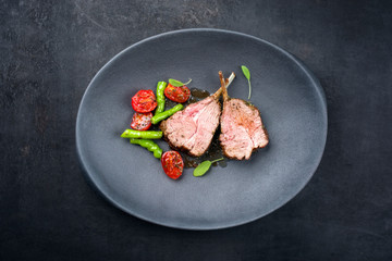 Barbecue rack of lamb neck with paprika and tomato offered as top view on a modern design plate...