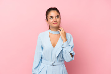 Young brunette girl over isolated pink background thinking an idea