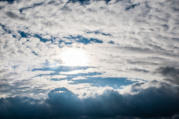 Naklejka na ściany i meble the sun's rays shine through the clouds. cloudy sky, background