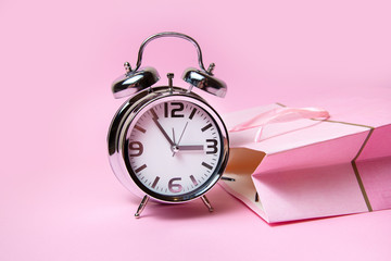 Alarm clock on a pink background , time to shopping 