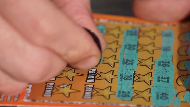 hand scratching a scratch card lottery ticket 4k