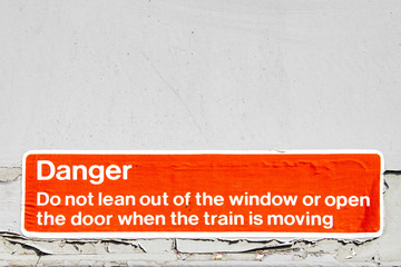 Eroded warning sign to not lean out of a train window