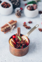 Red spiced mulled wine near berries, anise, orange slices and cinnamon