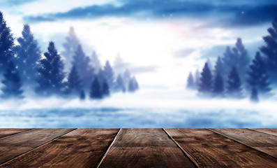 Wooden winter table. Winter empty scene, snowy trees, cold. Sunlight. Christmas day.