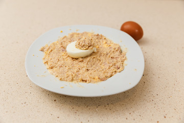 cocinando la receta de huevos rellenos de atún y mayonesa. en un plato se ve la mezcla y encima...