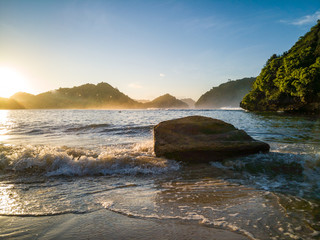 Wonderful view rock hit by weaves on beach in the morning