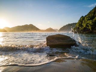 Obraz premium Wonderful view rock hit by weaves on beach in the morning