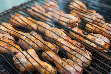 Closeup of chicken legs on the barbecue in outdoor
