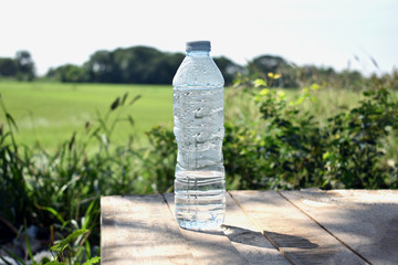 Water bottles on wooden floors, fields and background
