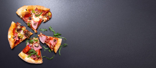 Italian pizza with ham and cheese on black background with copy space, top view