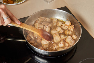 Woman frying bacon in pan