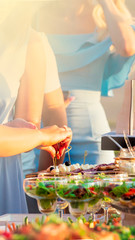 people catering outdoors buffet food in luxury restaurant with meat colorful fruits and vegetables. vertical