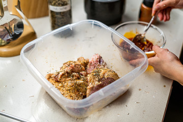 Marinated Raw Chicken Legs with Tomato Sauce, Onions, Rosemary and Potatoes Ready to Bake in Oven.