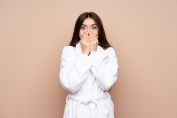 Young girl in a bathrobe over isolated background with surprise facial expression