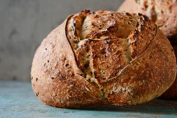 Homemade Freshly Baked Country Bread  made from wheat and whole grain flour on a gray-blue background. French Freshly baked bread.