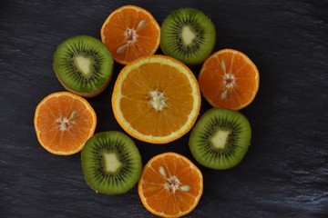 halves of tropical fruits, clementines, oranges, kiwi and mango