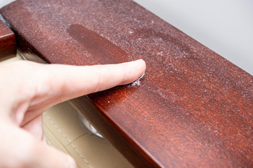 A finger swiping dust from furniture, dusty home concept