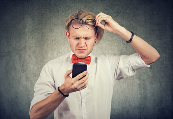 man with glasses using mobile phone on having vision problem