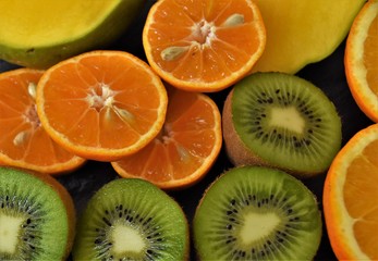  halves of tropical fruits, clementines, oranges, kiwi and mango