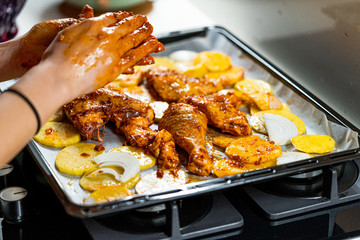 Marinated Raw Chicken Legs with Tomato Sauce, Onions, Rosemary and Potatoes Ready to Bake in Oven.