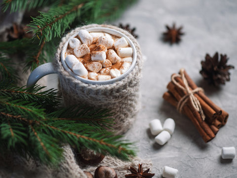 Hot Winter Drink Chocolate, Cocoa Or Coffee With Marshmallows On The Table In A Knitted Mug With Cinnamon