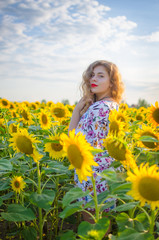 Happy girl with blond long hair on a field of sunflowers