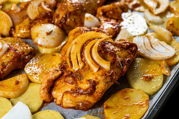 Marinated Raw Chicken Legs with Tomato Sauce, Onions, Rosemary and Potatoes Ready to Bake in Oven.